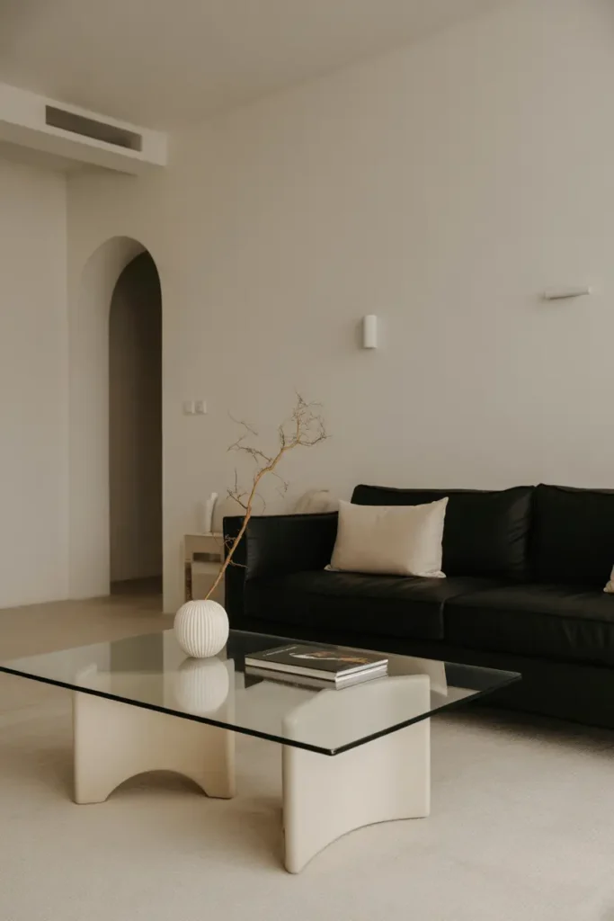 Modern minimalist living room with a black couch, clean lines, and soft lighting.