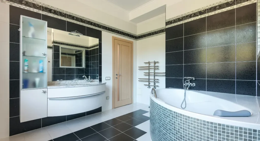 Modern black and white bathroom with geometric floor tiles, white walls, and black accents in a clean minimalist design.