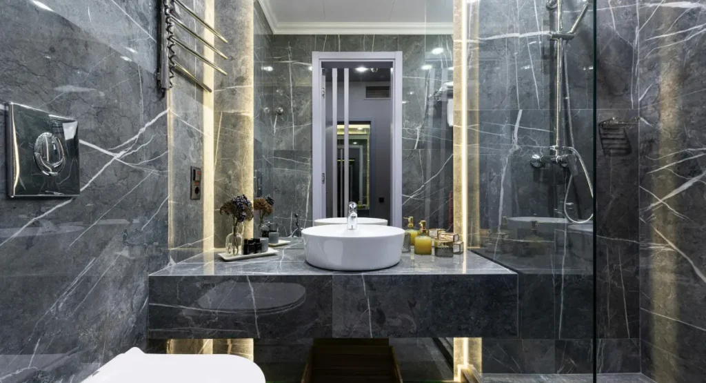 Elegant black bathroom vanity with white countertop and gold hardware in a modern luxury bathroom design.