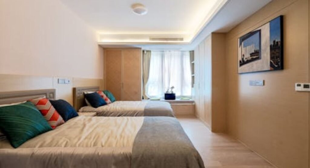 luxury twin bedroom with upholstered headboards, neutral bedding, and symmetrical design creating an elegant shared space