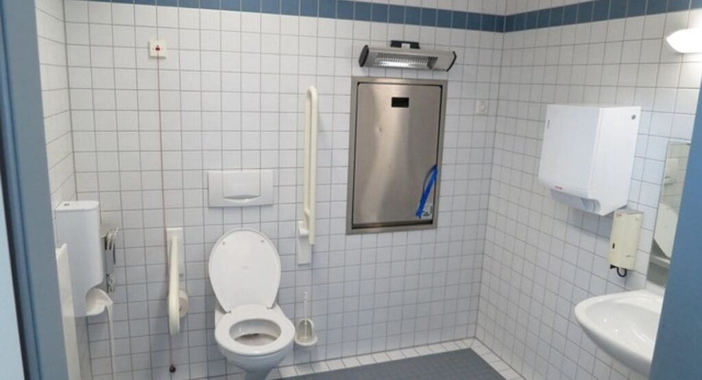 Space-saving over-the-toilet storage unit in a college bathroom.